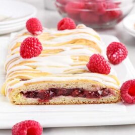 close up shot of raspberry breakfast braid on a plate with raspberries on the side