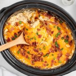 overhead shot of Crockpot Crack Chicken and Rice in a crockpot with a wooden spoon