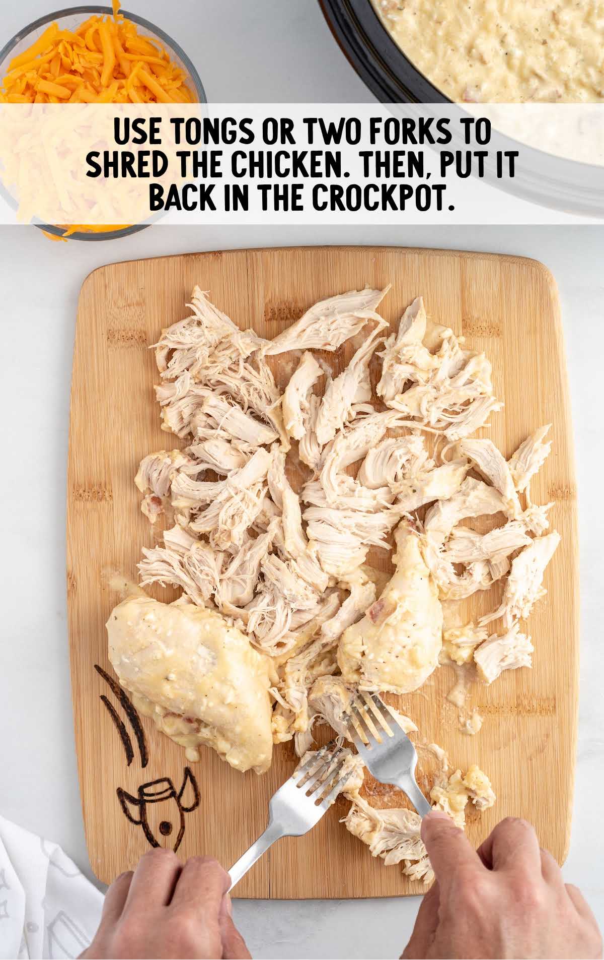 shredded chicken on a cutting board with forks
