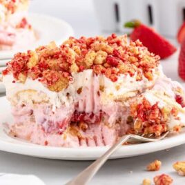 close up shot of a slice of Strawberry Shortcake Icebox Cake on a plate with a fork
