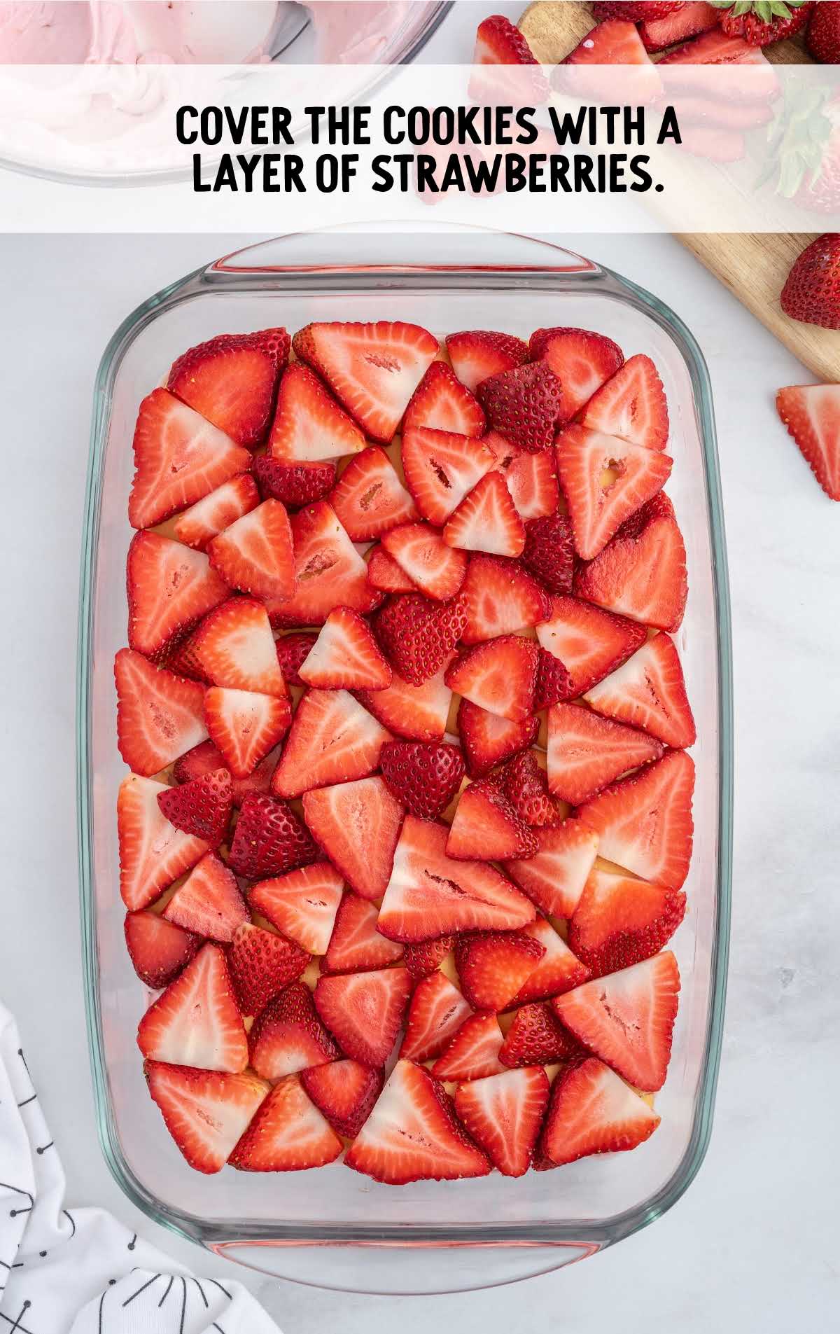 cookies covered with a layer of strawberries in a baking dish