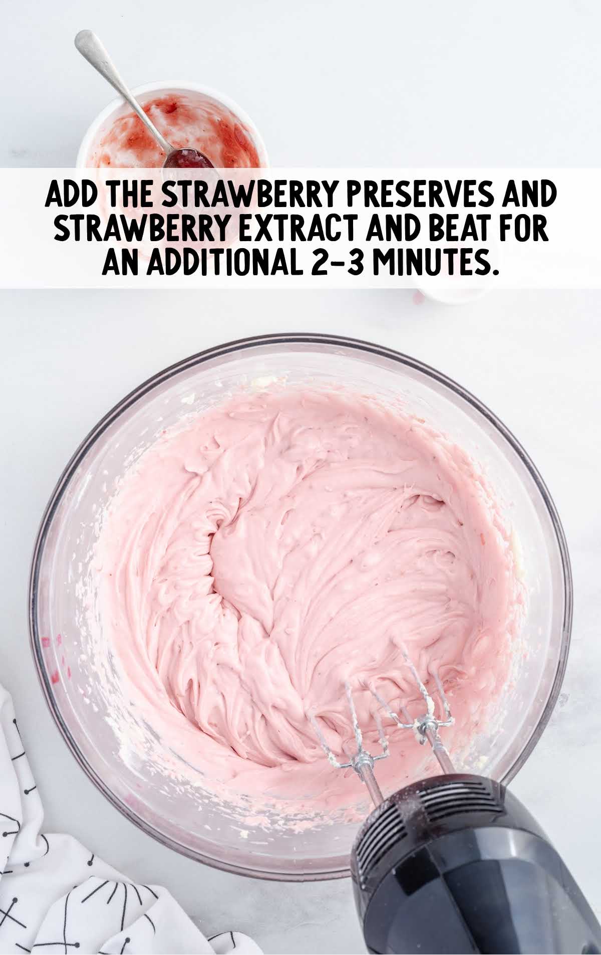 strawberry preserves and strawberry extract added to the cream cheese mixture in a bowl and blended
