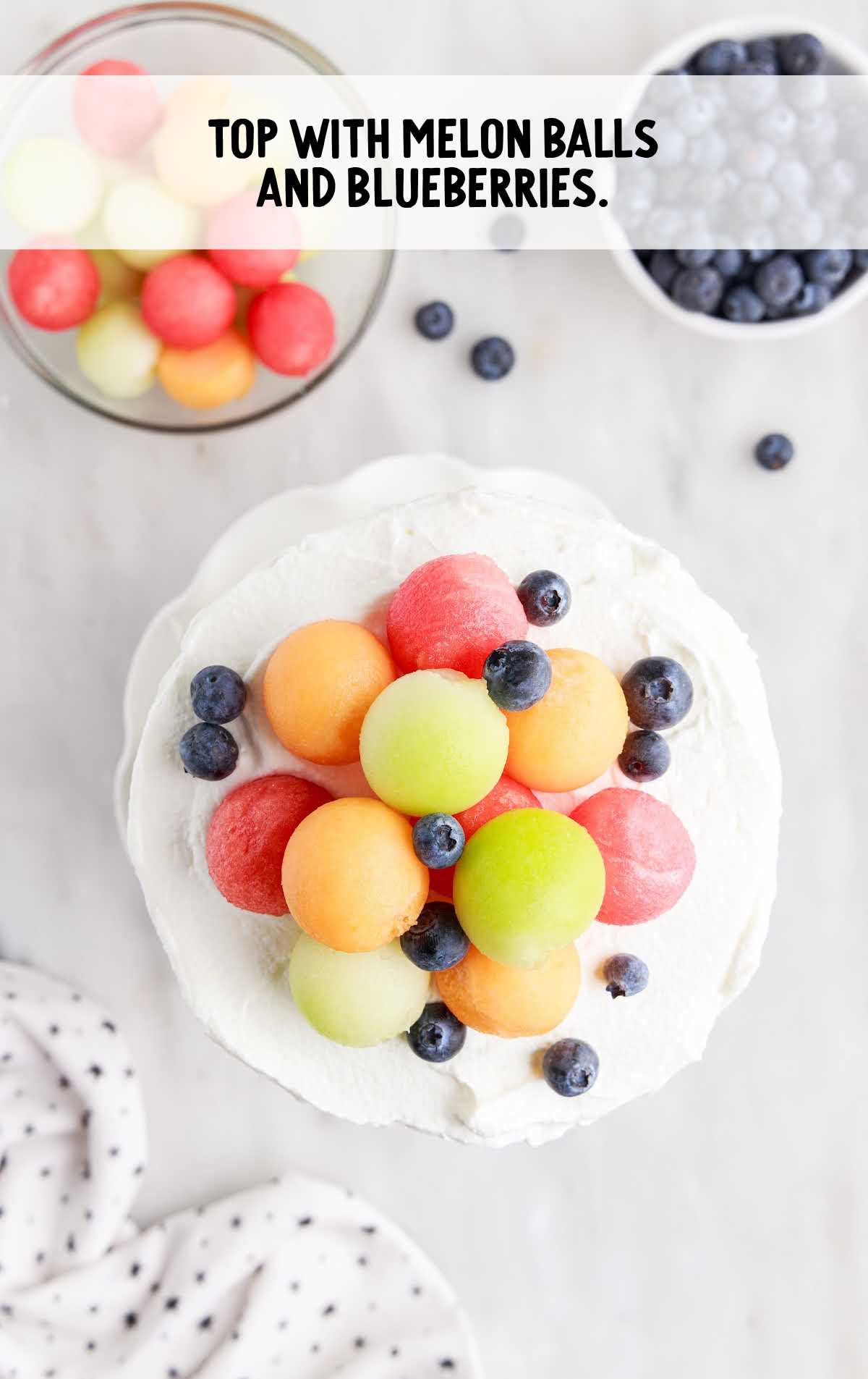 cake topped with melon balls and blueberries