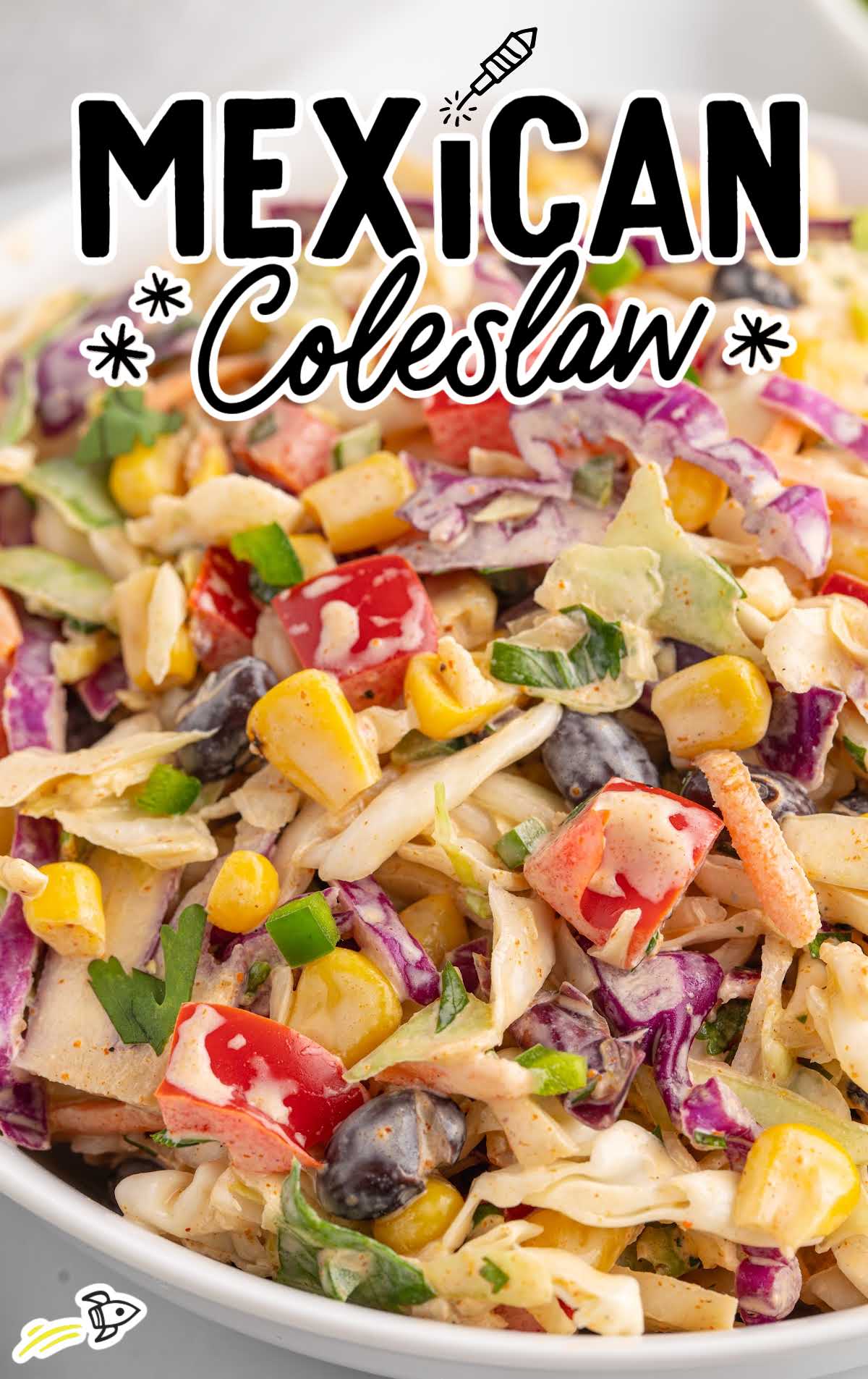 Bowl of vibrant Mexican coleslaw made with shredded cabbage, red peppers, corn, and black beans.