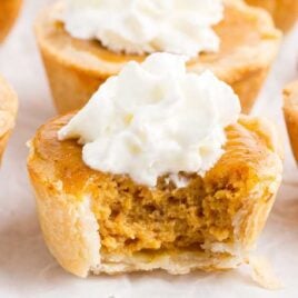 a close up shot of Mini Pumpkin Pie with a bite taken out