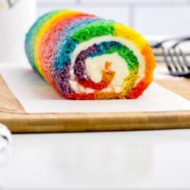 close up shot of Rainbow Roll Cake on a wooden board