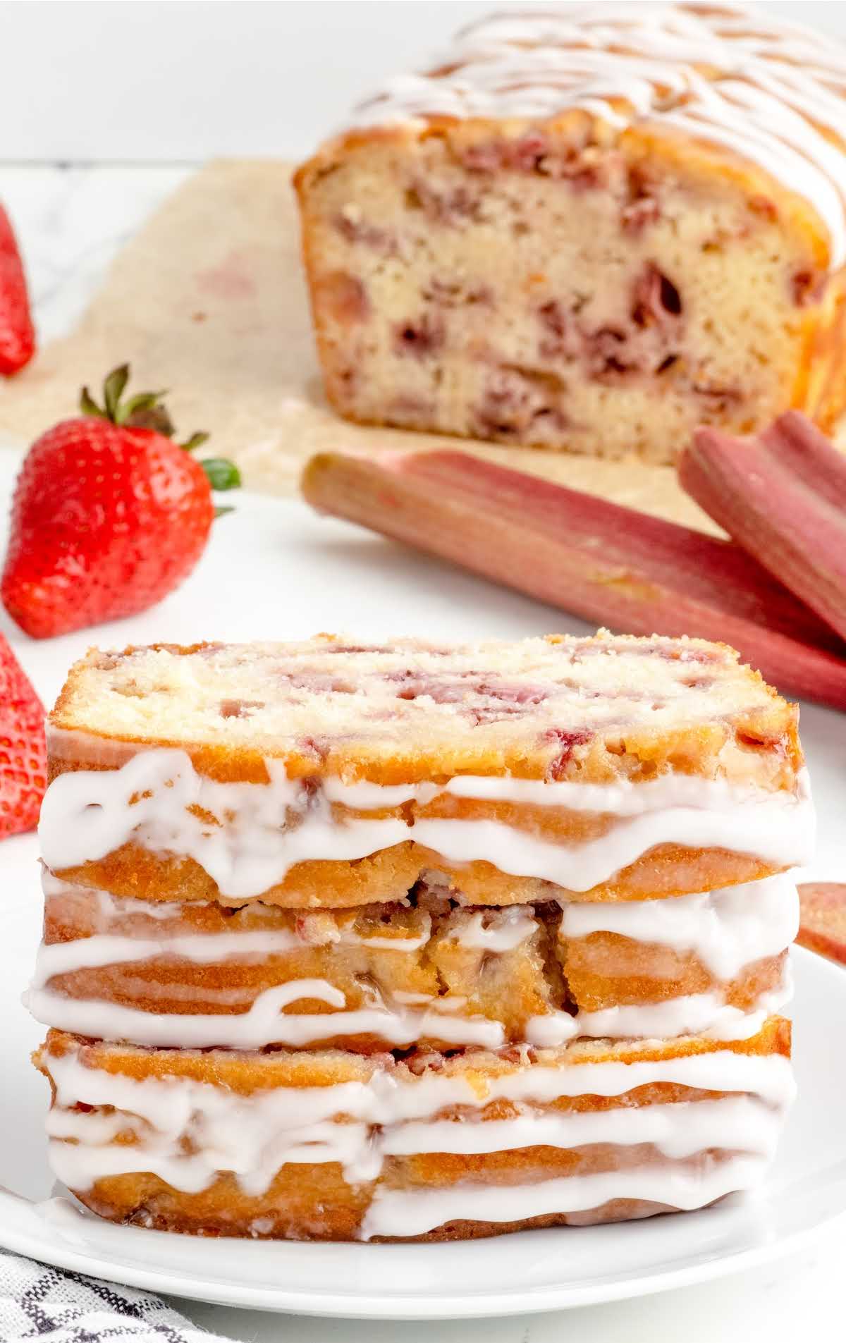close up shot of slices of strawberry rhubarb bread stacked on top of each other on a plate