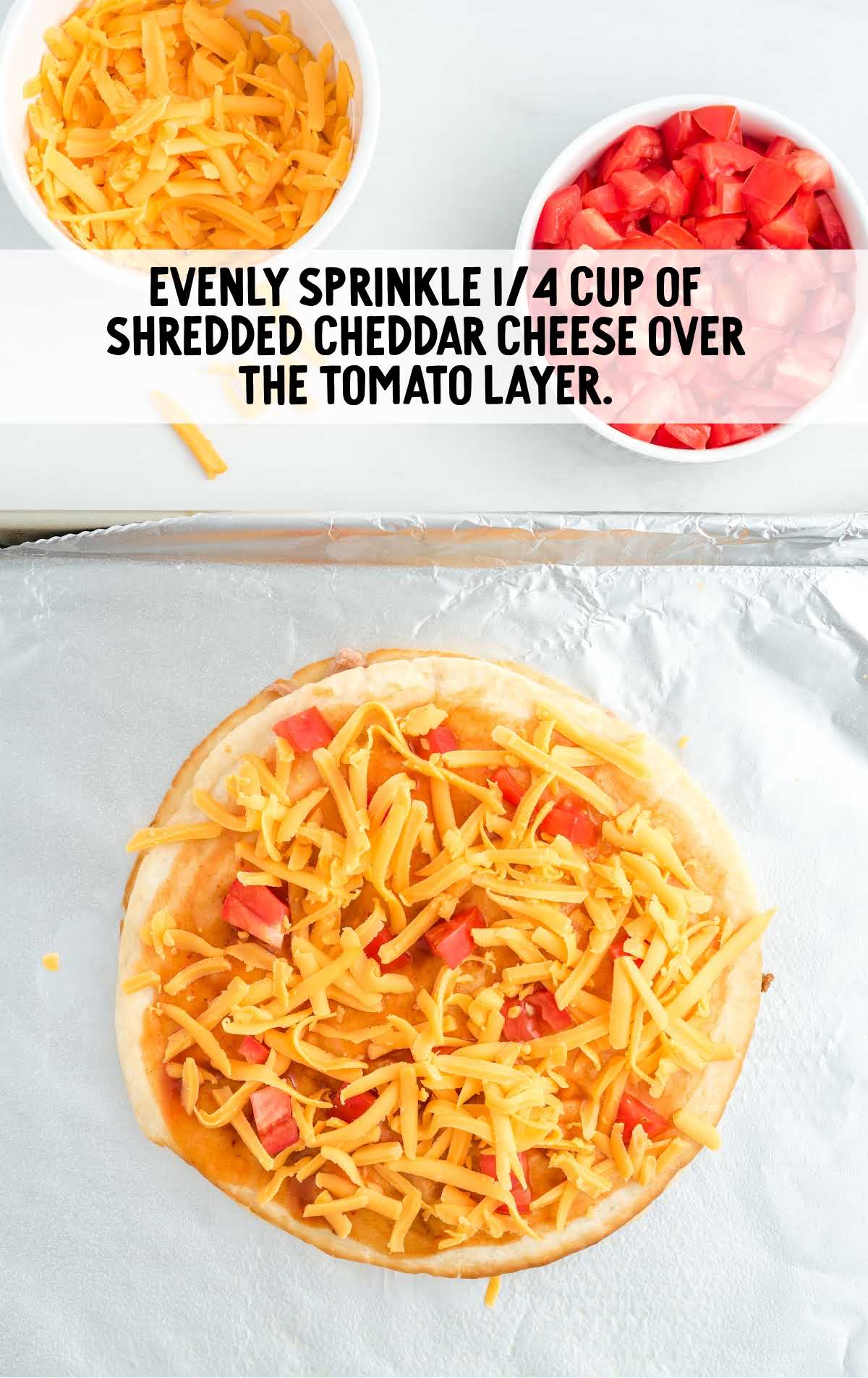 shredded cheese sprinkled over the tomato layer