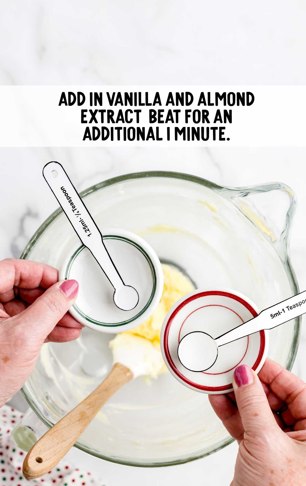 vanilla and almond extract added to the butter mixture in a cup