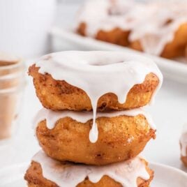 a close up shot of Cinnamon Roll Donuts stacked on top of each other