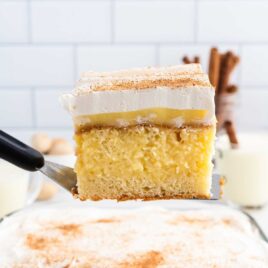 A close up shot of a slice of Eggnog Poke Cake on a spatula