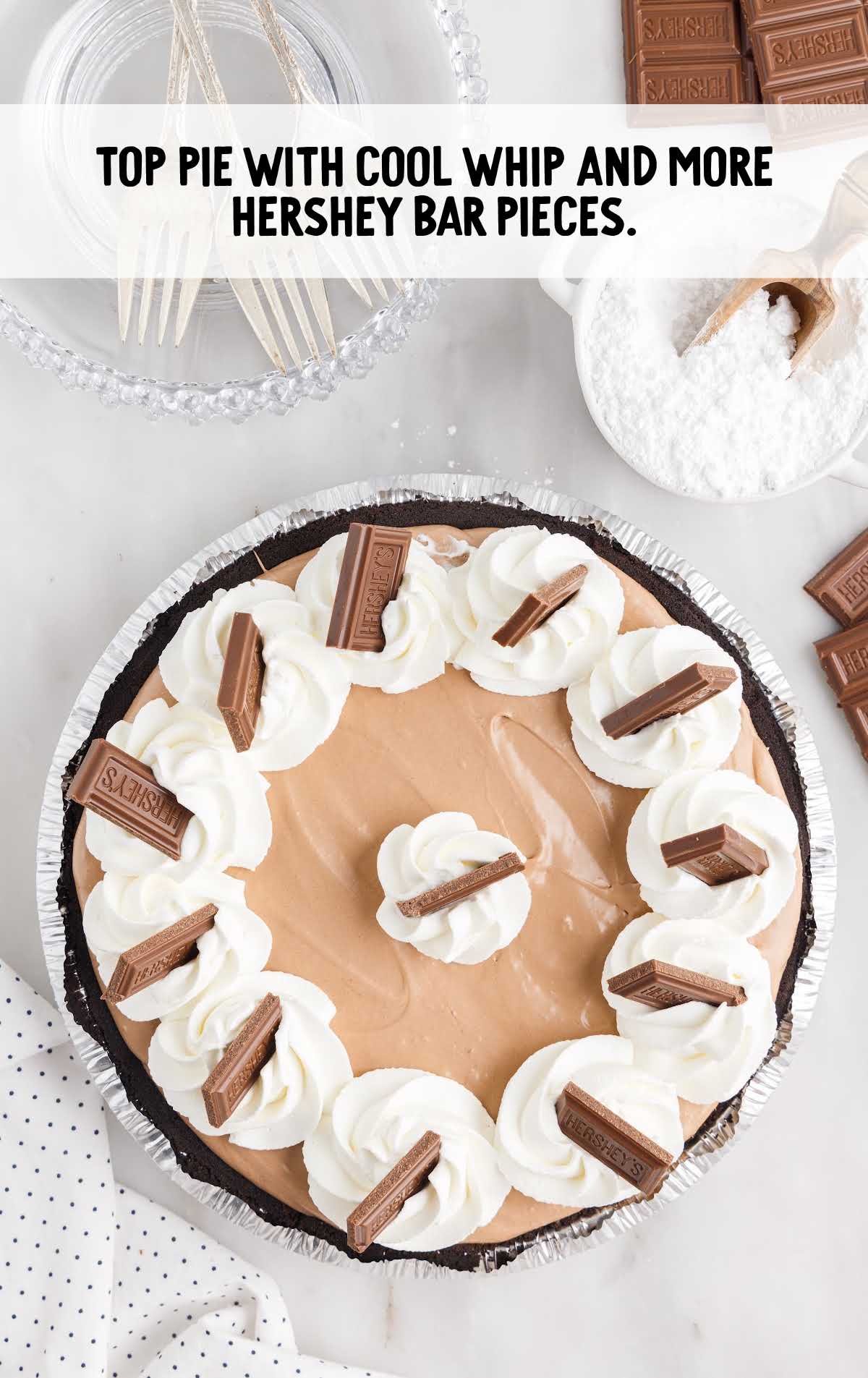 cool whip and Hershey bar pieces topped on top of the pie