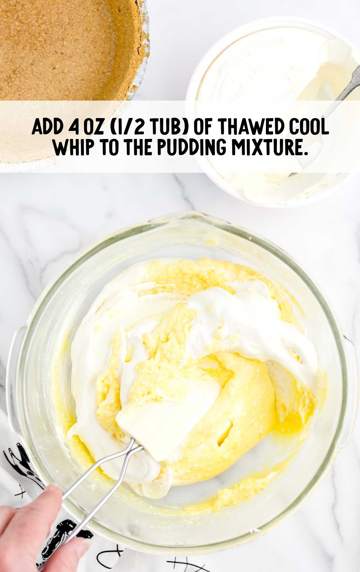 thawed cool whip added to the pudding mixture in a bowl