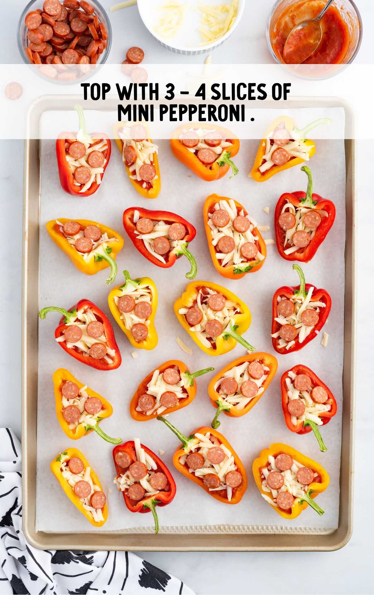 pepper pizza bites topped with pepperoni slices on a baking tray