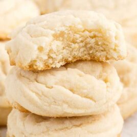 a close up shot of Amish Sugar Cookies stacked on top of each other and with one having a bite taken out