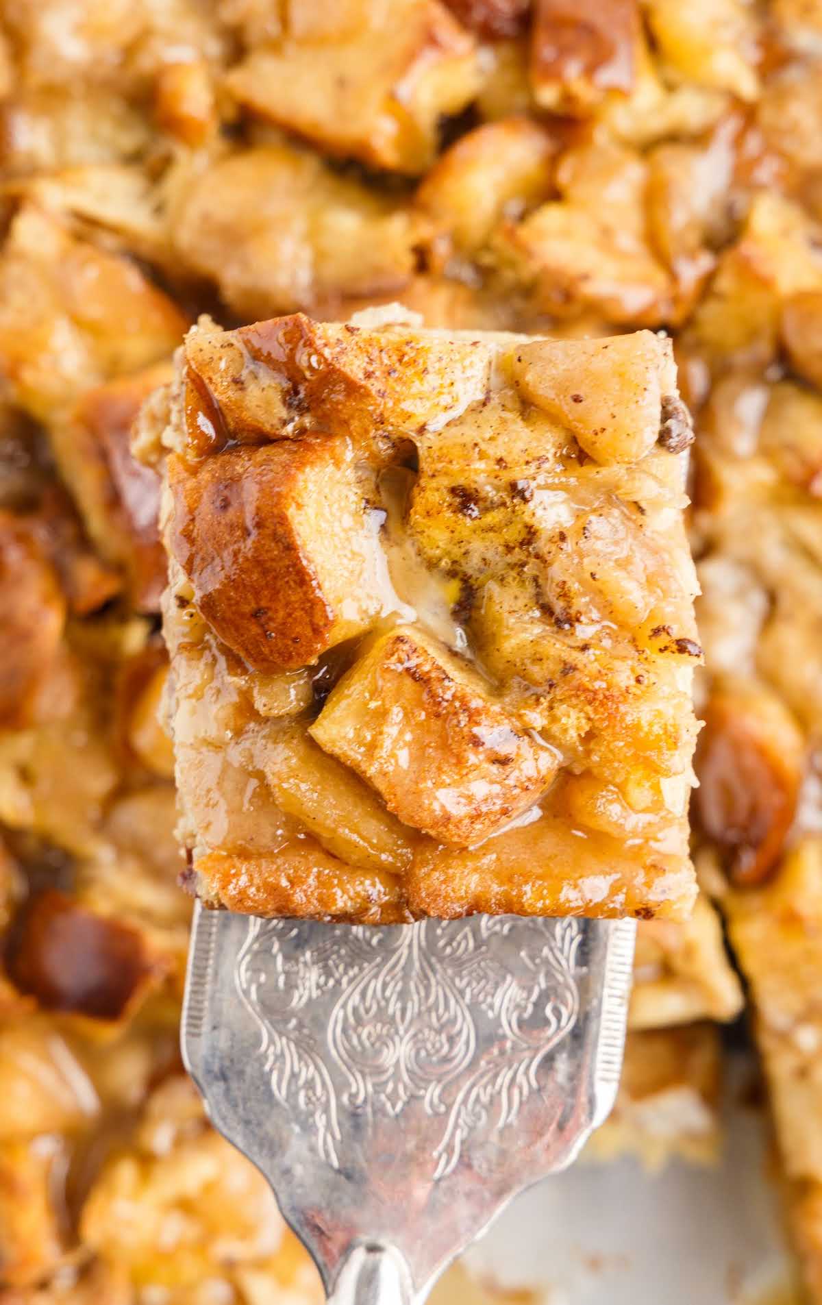 a overhead shot of a piece of apple bread pudding on a spatula