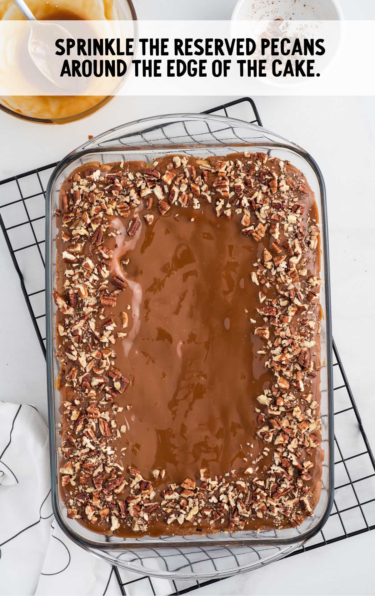 reserved pecans sprinkled around the edge of the cake in a baking dish