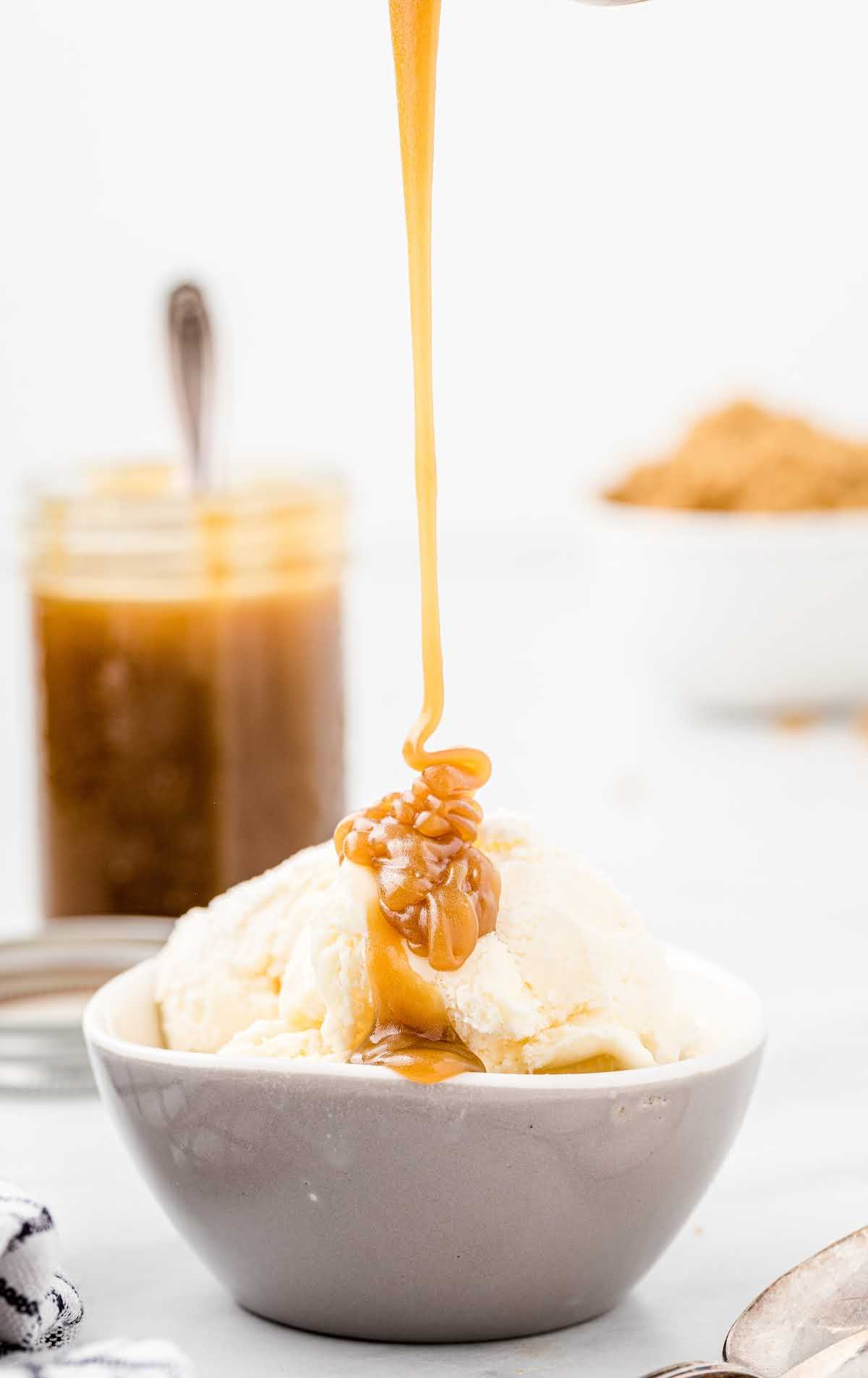 a close up shot of Butterscotch Sauce being poured on top of an ice cream