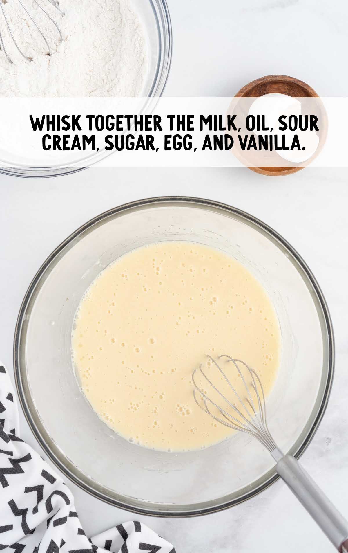 milk, oil, sour cream, sugar, egg, and vanilla whisked in a bowl