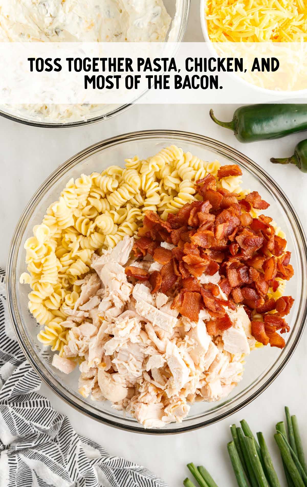 pasta, chicken, and bacon tossed in a bowl