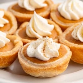 Close-up of mini pumpkin pies with flaky crust and creamy pumpkin filling