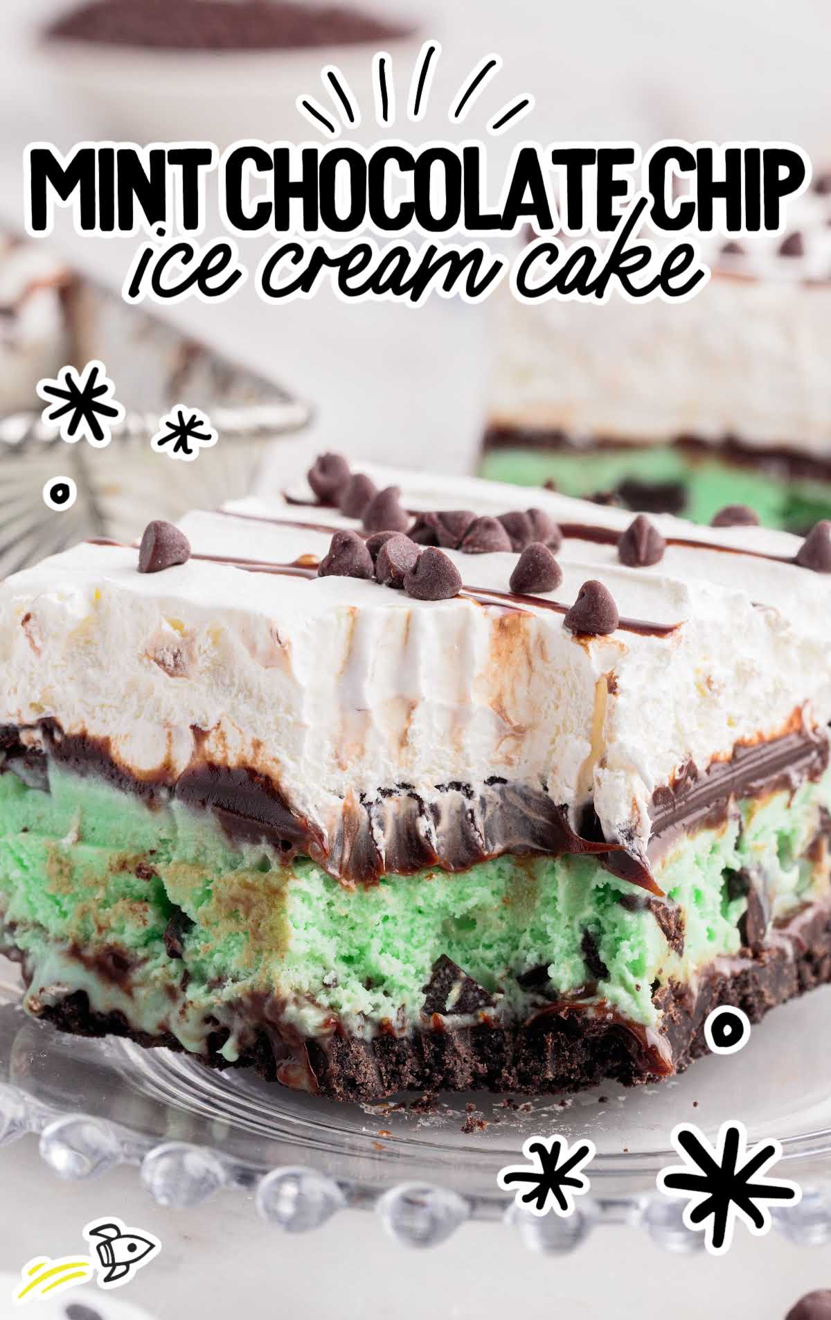 a close up shot of a slice of Mint Chocolate Chip Ice Cream Cake on a plate with a bite taken out