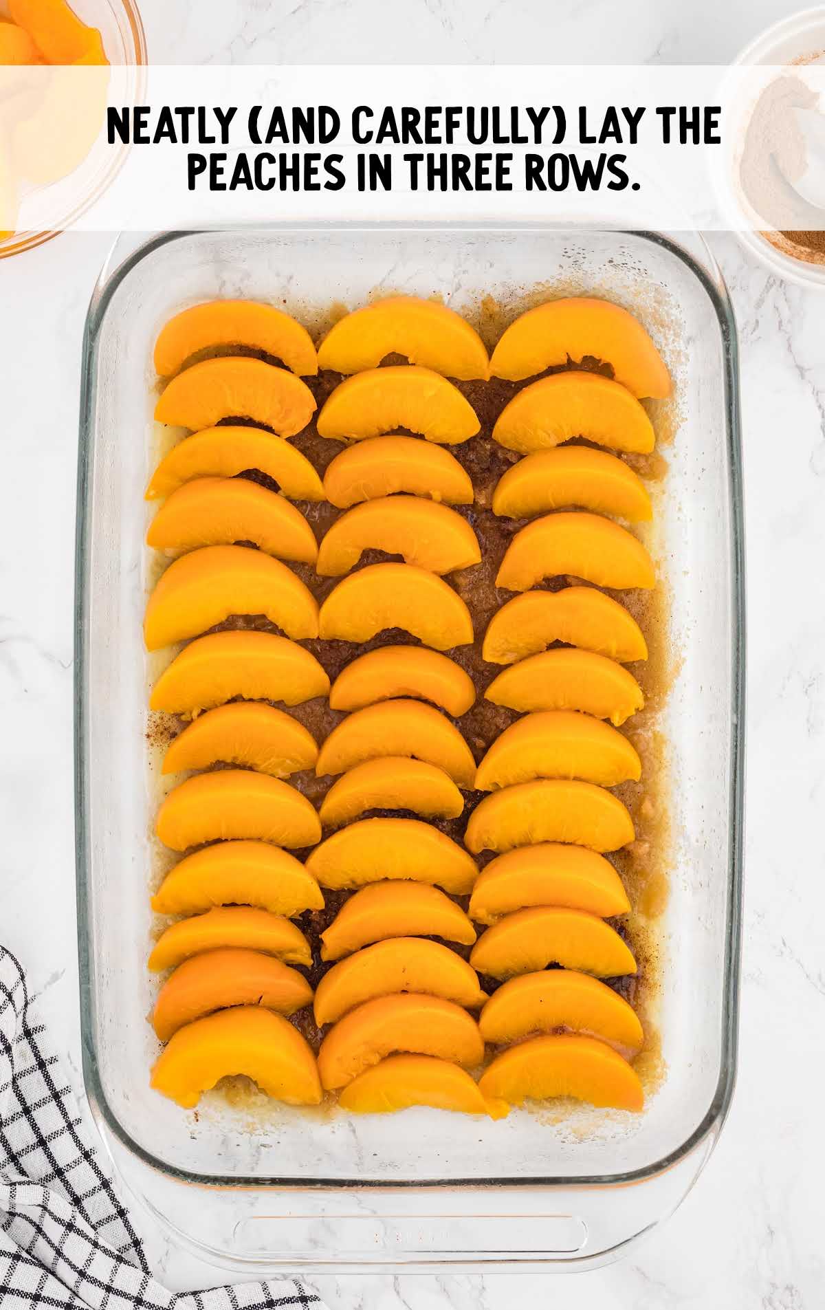 peaches laid in three rows in a baking dish