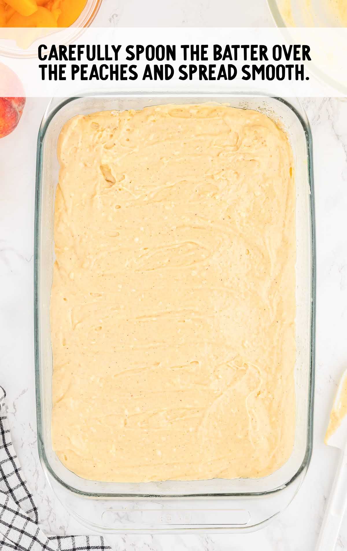 batter spread over the peach in a baking dish