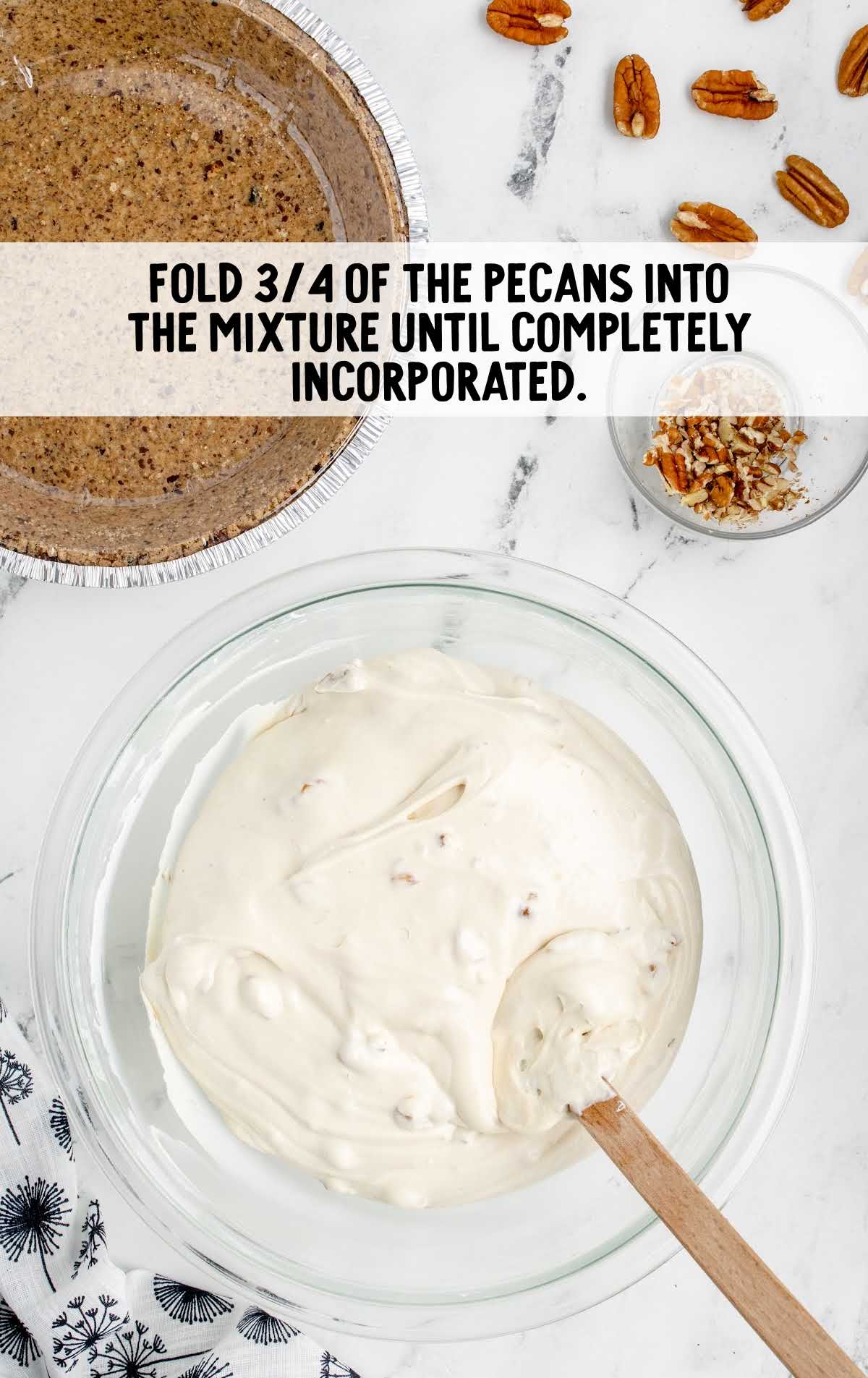 pecans folded with the cool whip mixture in a bowl