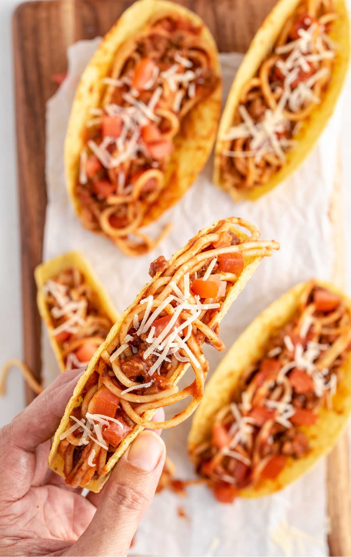 overhead shot of Spaghetti Tacos on a wooden board