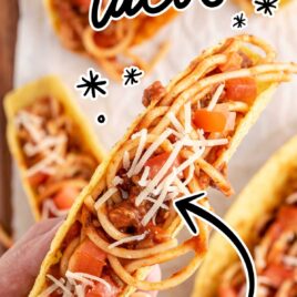 overhead shot of Spaghetti Tacos on a wooden board