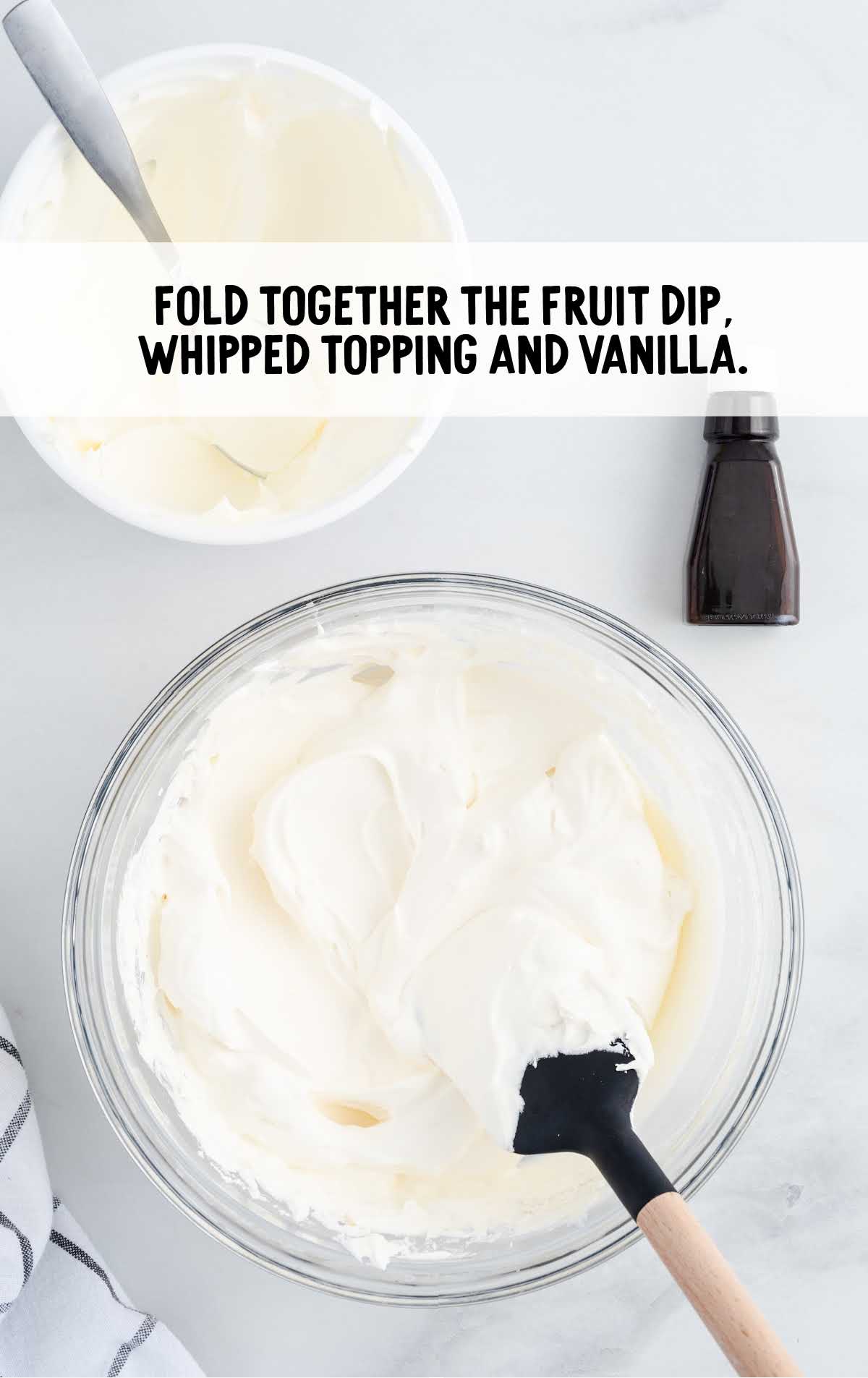fruit dip, whipped topping and vanilla folded in a bowl