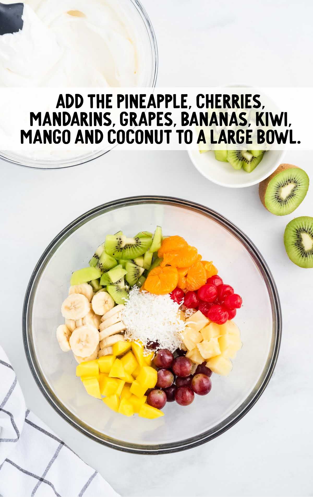 pineapple, cherries, mandarins, grapes, bananas, kiwi, mango, and coconut added to a large bowl