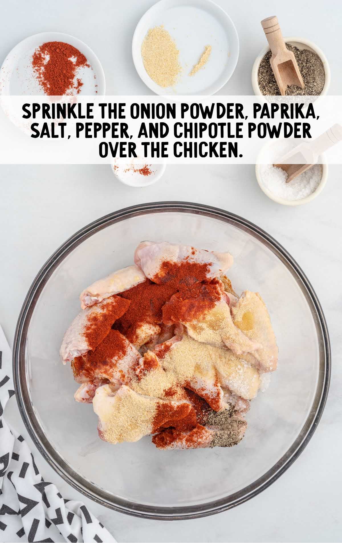 onion powder, paprika, salt, pepper, and chipotle powder sprinkled over the chicken in a bowl