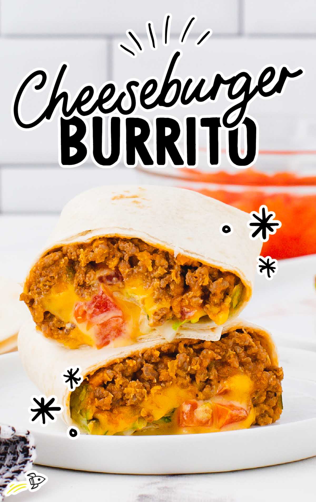 A close up shot of a Cheeseburger Burrito split in half on a plate