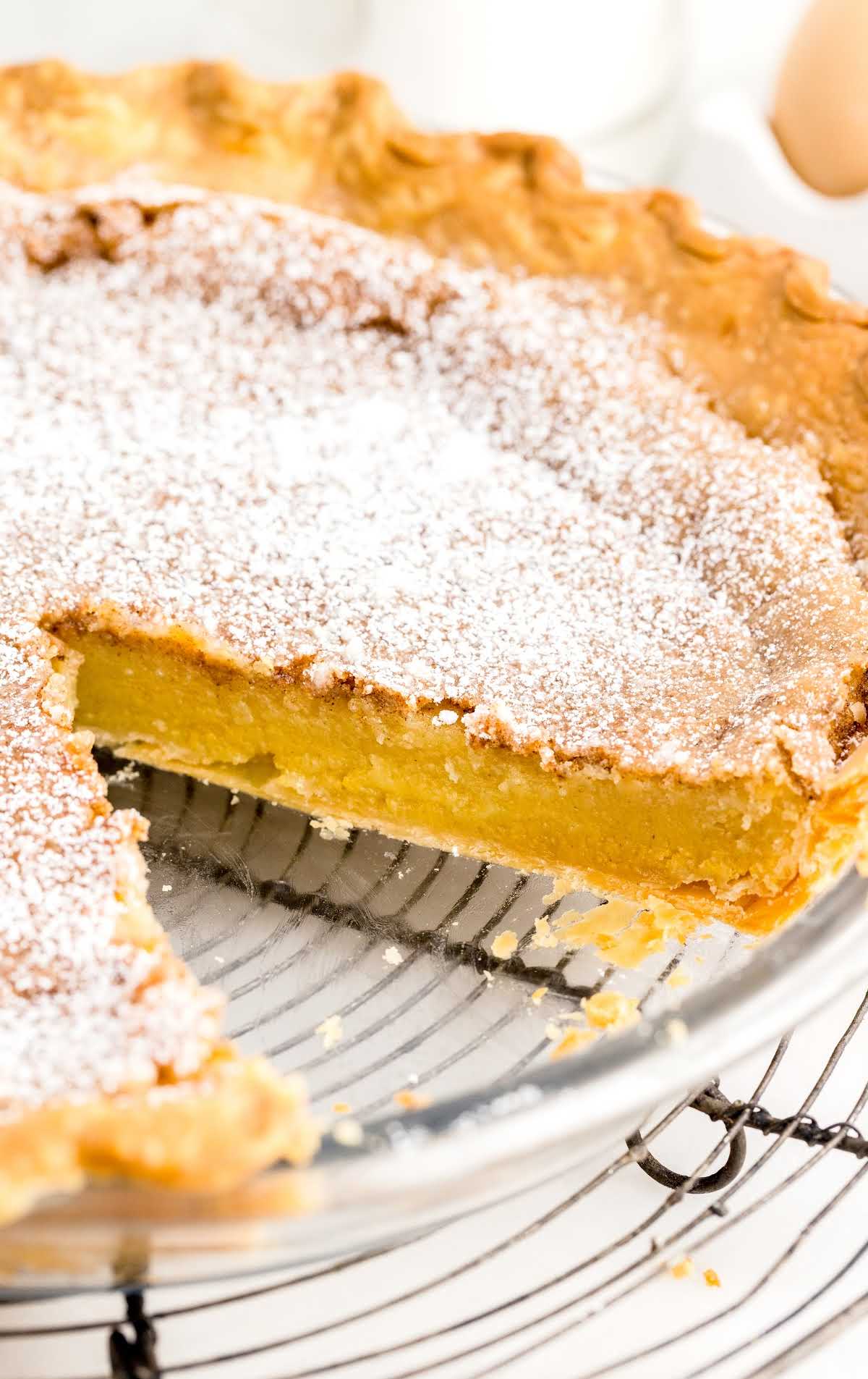 a close up shot of a Chess Pie on a cooling rack with a slice taken out
