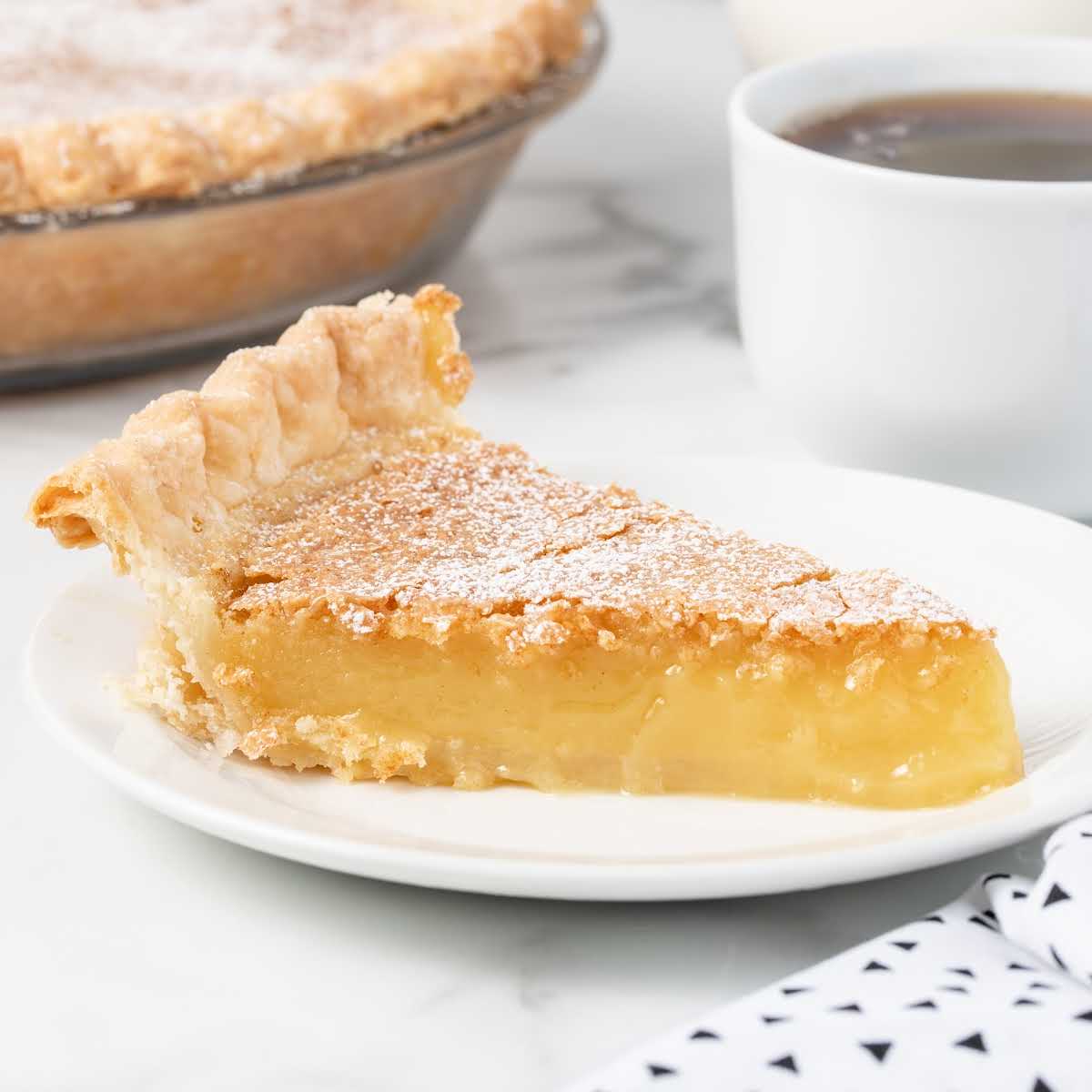 a close up shot of a slice of Chess Pie dusted with powdered sugar on a plate