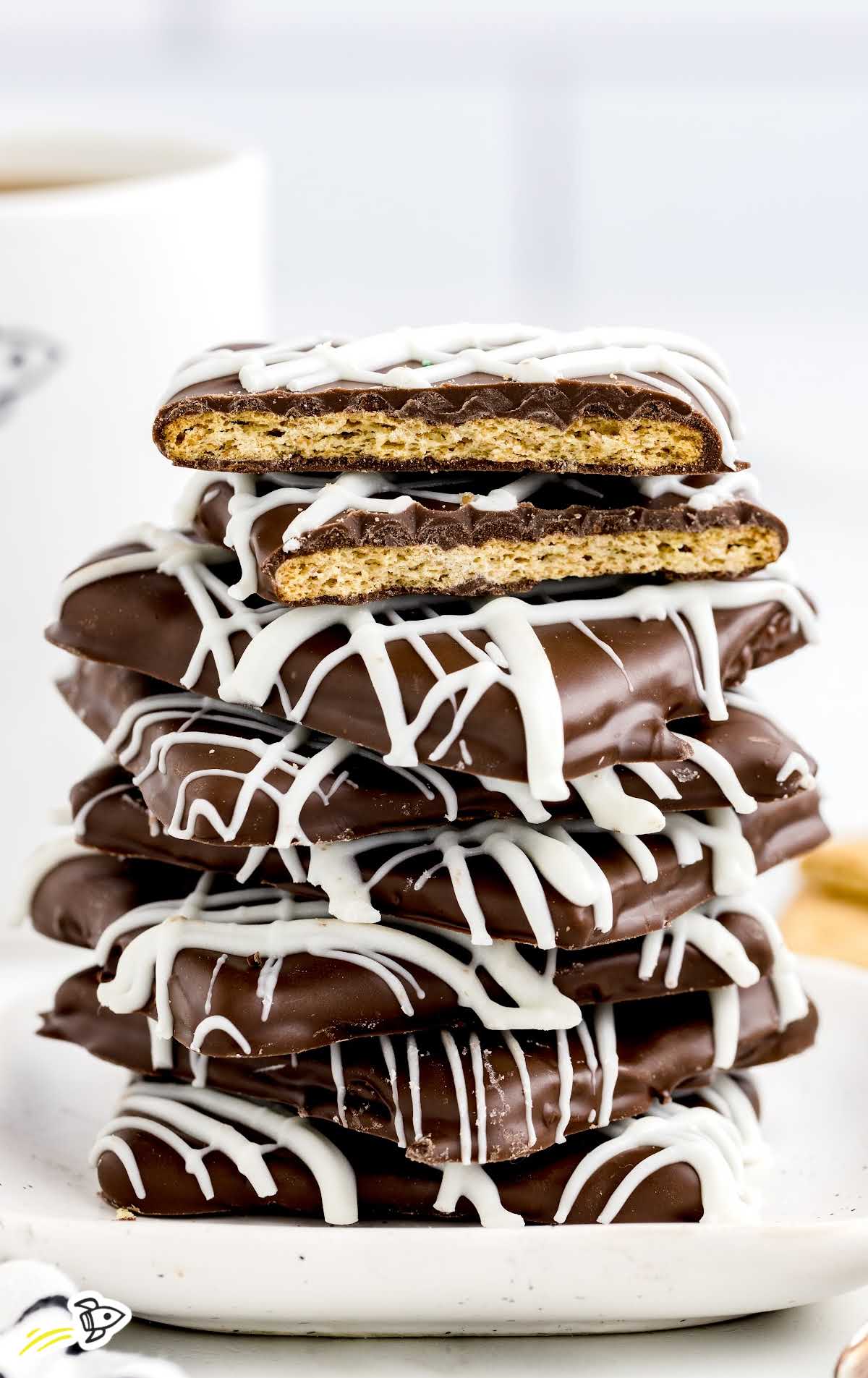 close up shot of Chocolate Covered Graham Crackers on a plate stacked on top of each other with one split in half