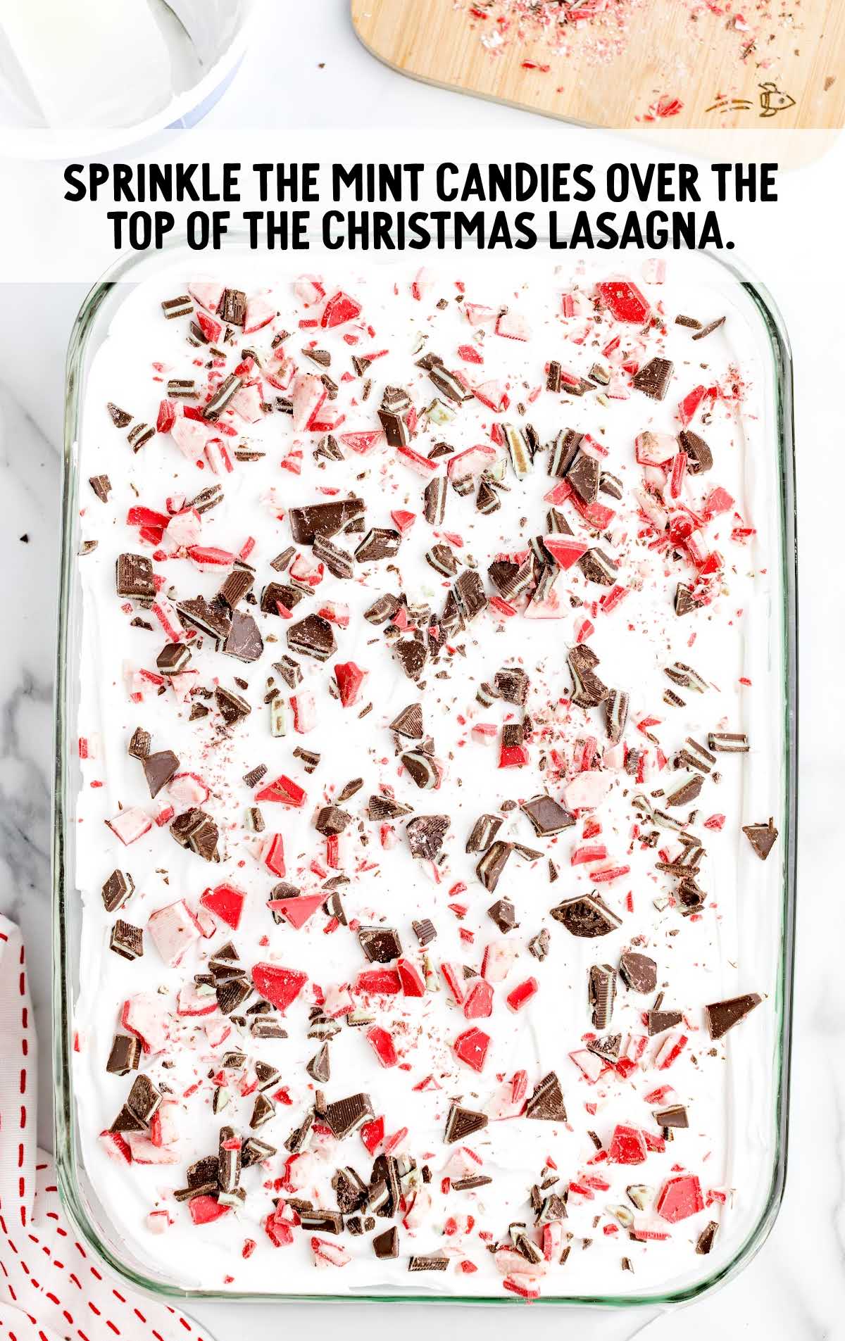 mint candies sprinkled over the lasagna in a baking dish