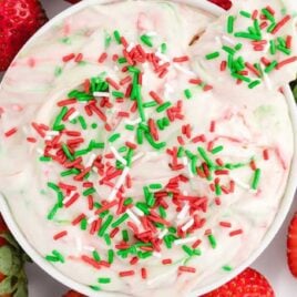 overhead shot of Christmas Sugar Cookie Dip in a bowl topped with a graham cracker