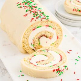 a close up shot of a slice of Christmas Vanilla Roll Cake with a piece cut off