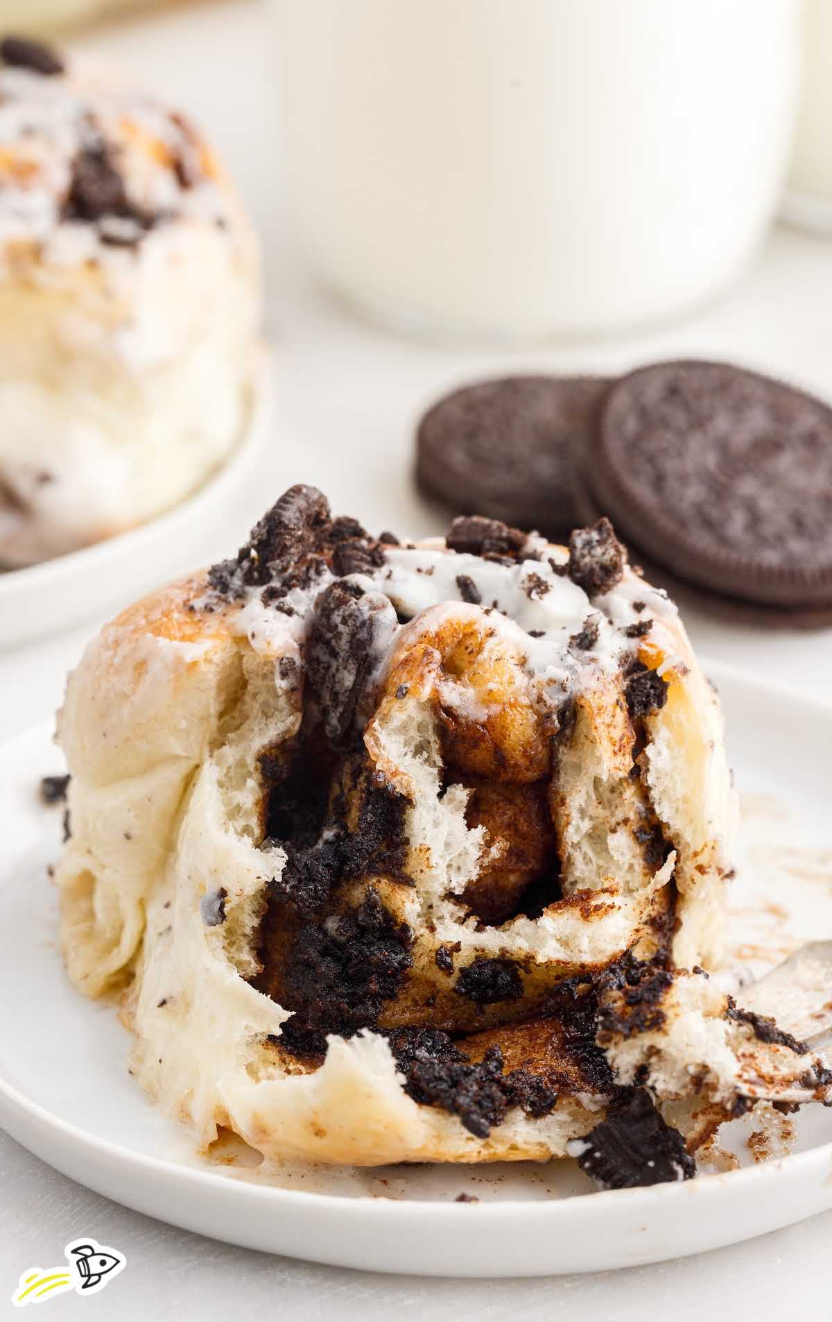 a close up shot of a slice of Cookies and Cream Cinnamon Rolls on a plate