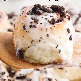 a close up shot of a piece of Cookies and Cream Cinnamon Rolls on a wooden spoon