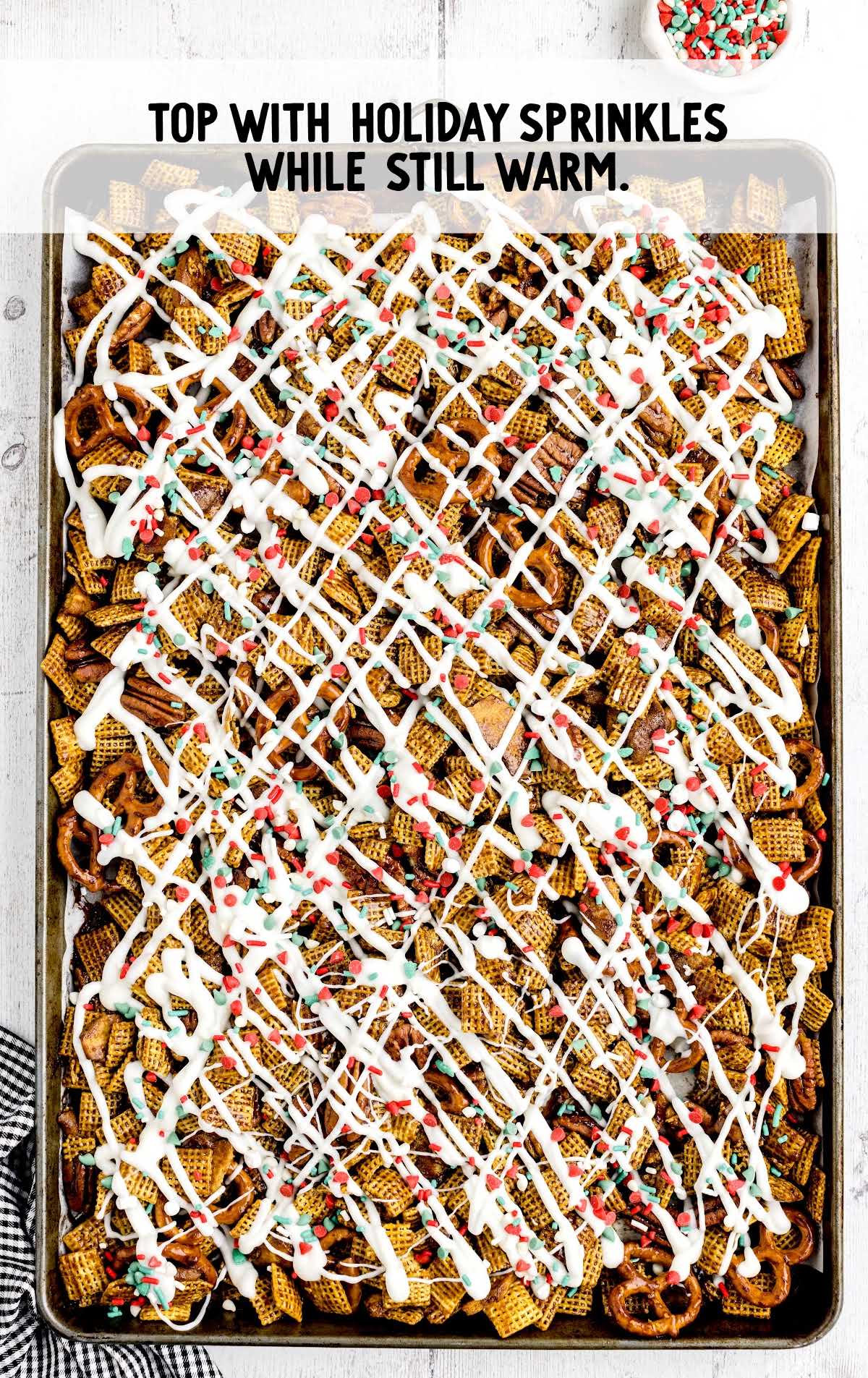 sprinkles sprinkled on top of the chex mix on a baking sheet