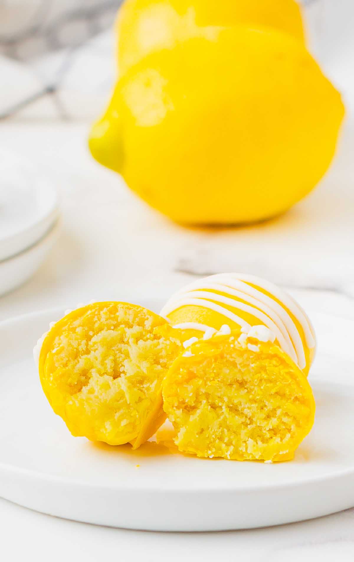 a close up shot of a couple of Lemon Cheesecake Bites with one split in half
