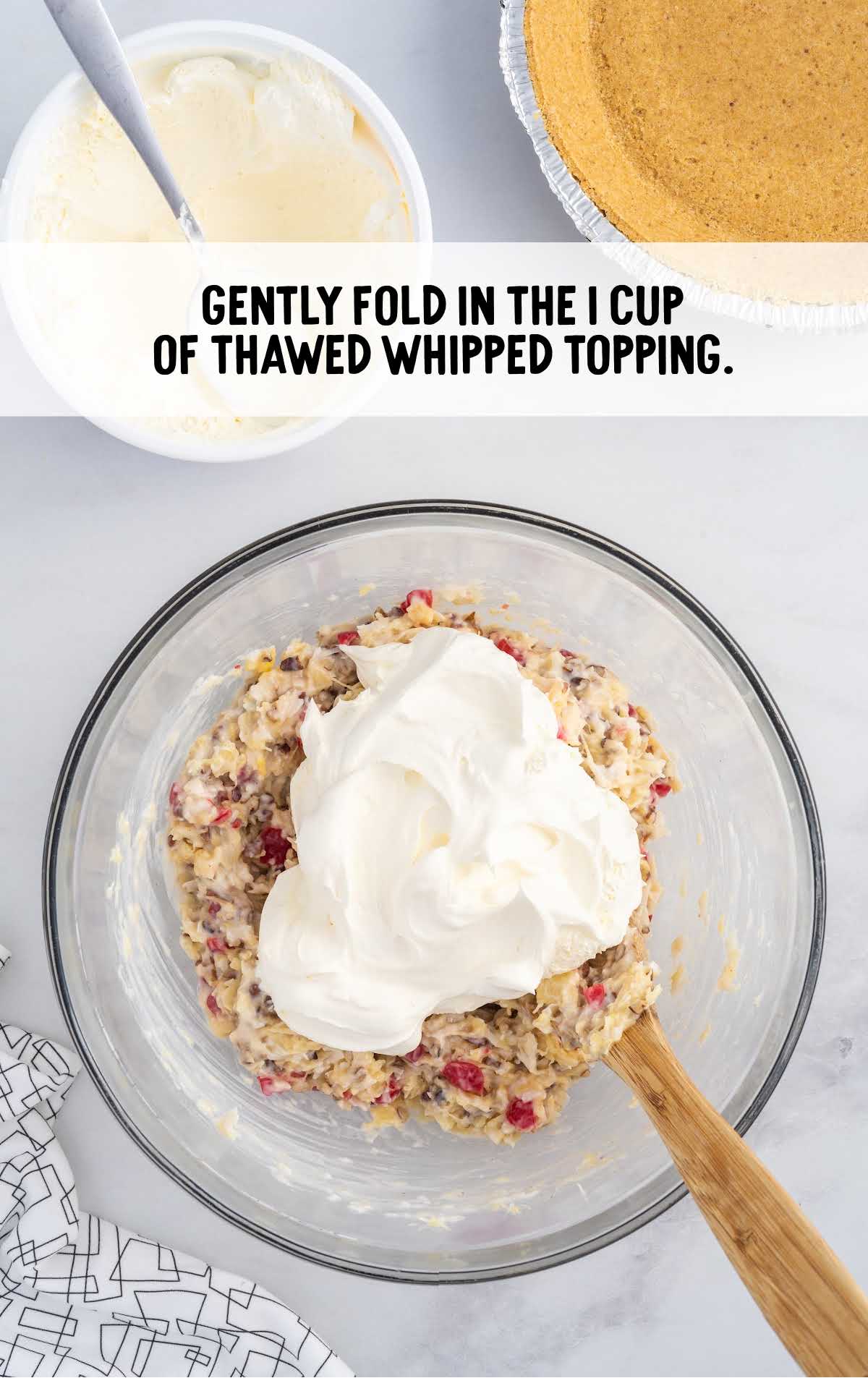 whipped topping added to the coconut flakes mixture and folded in a bowl