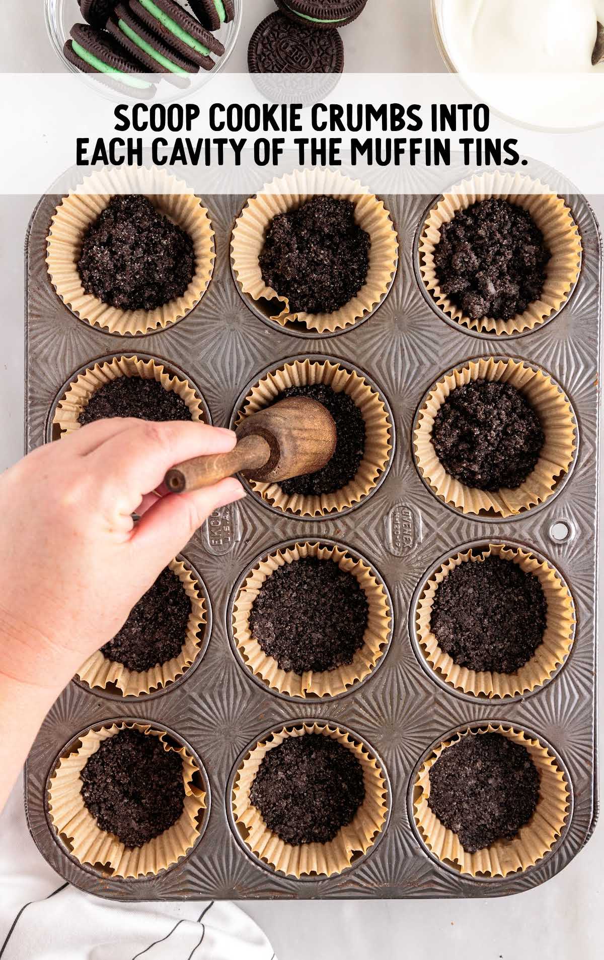cookie crumbs scooped into each cavity of the muffin tins