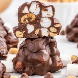 a close up shot of Peanut Marshmallow Cluster with a bite taken out of it stacked on top of another cluster