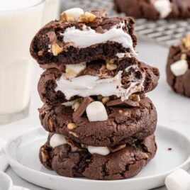 a close up shot of Rocky Road Cookies stacked on top of each other on a plate