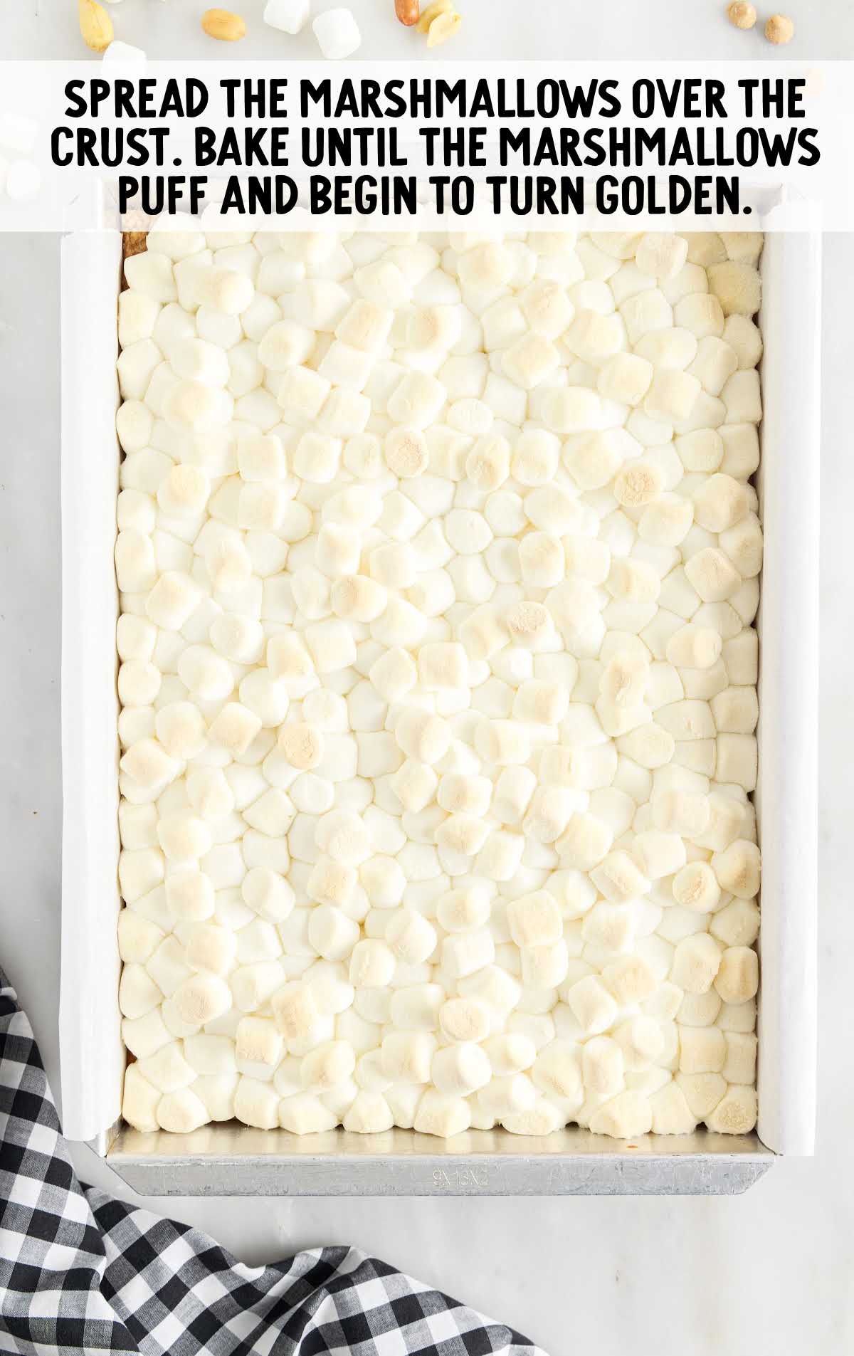 marshmallows spread over the crust in a baking dish